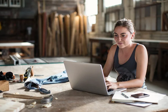 Person arbeitet an Laptop in Werkstatt